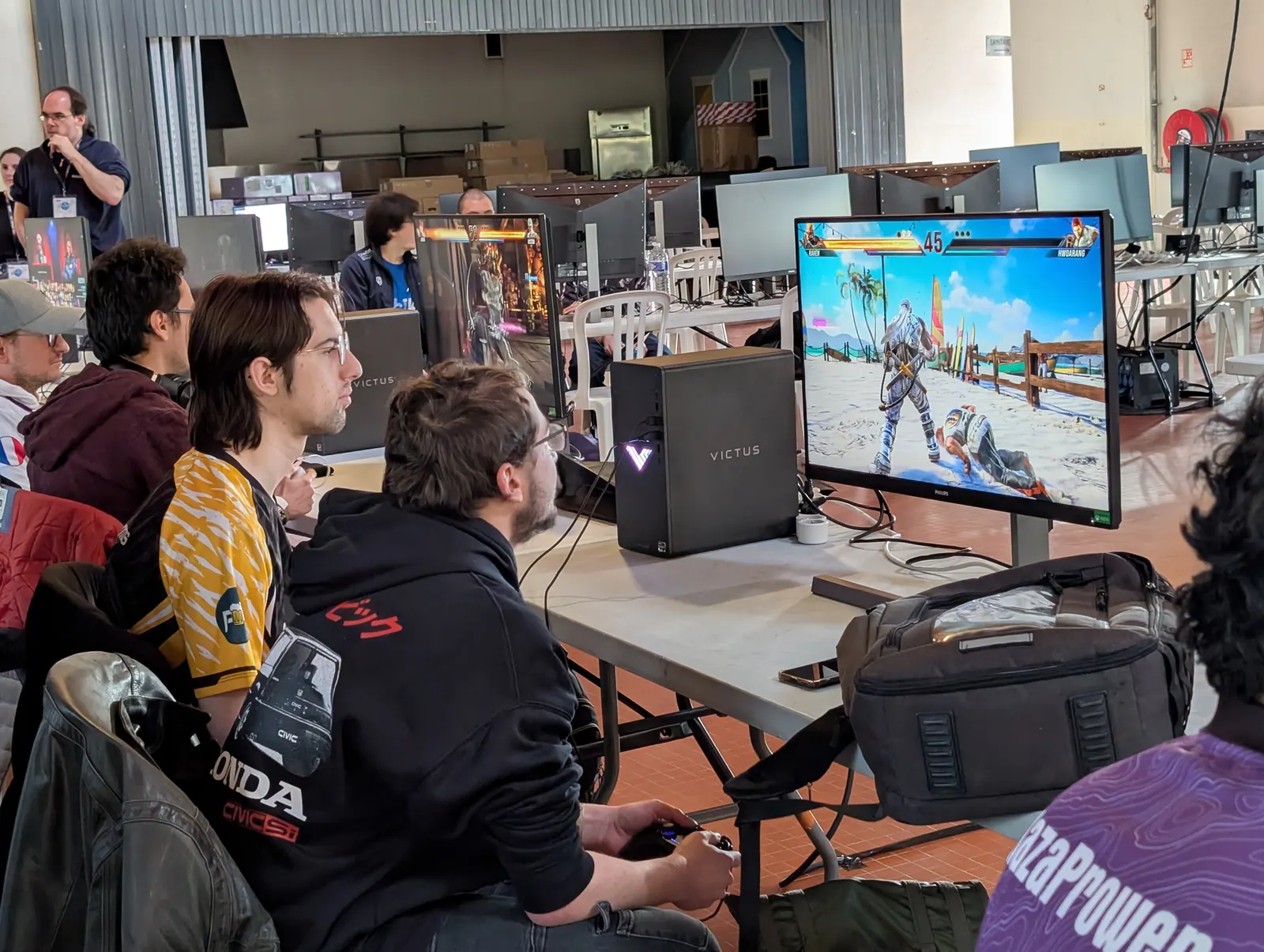 Compétiteurs installés sur un stand de tournoi en convention